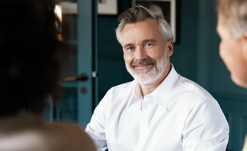 Personer i møde med ejendomsmægler smiler