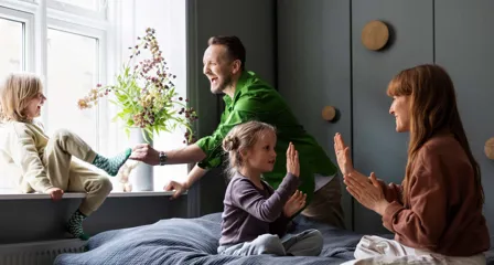Familie med to voksne og to børn leger sammen