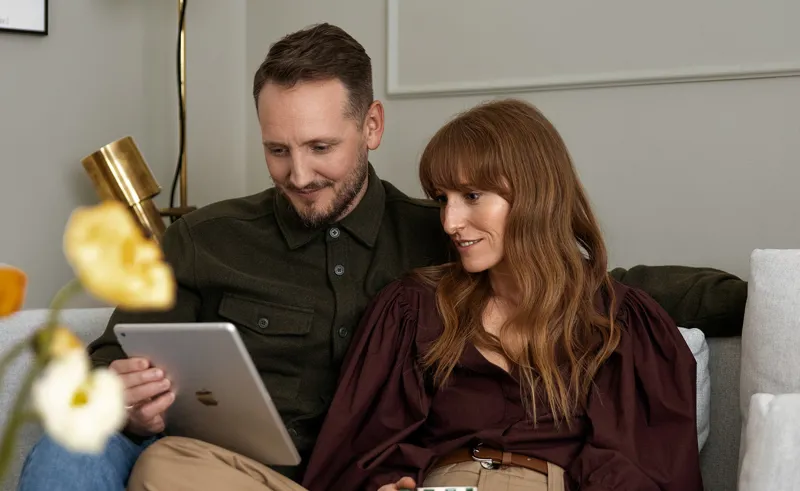 Par sidder i sofaen med iPad