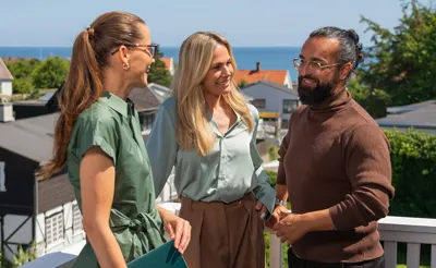 Par står med ejendomsmægler på terrasse på potentiel bolig