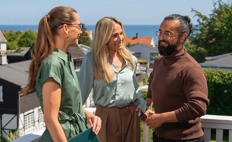 Par står med ejendomsmægler på terrasse på potentiel bolig