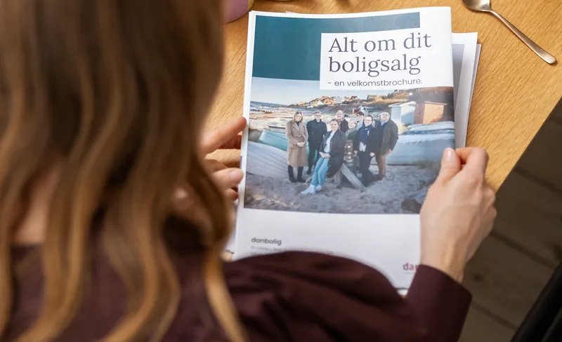 Kvinde læser velkomstbrochure fra danbolig