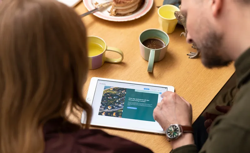 To personer sidder med iPad og tilmelder sig danboligs nyhedsbrev