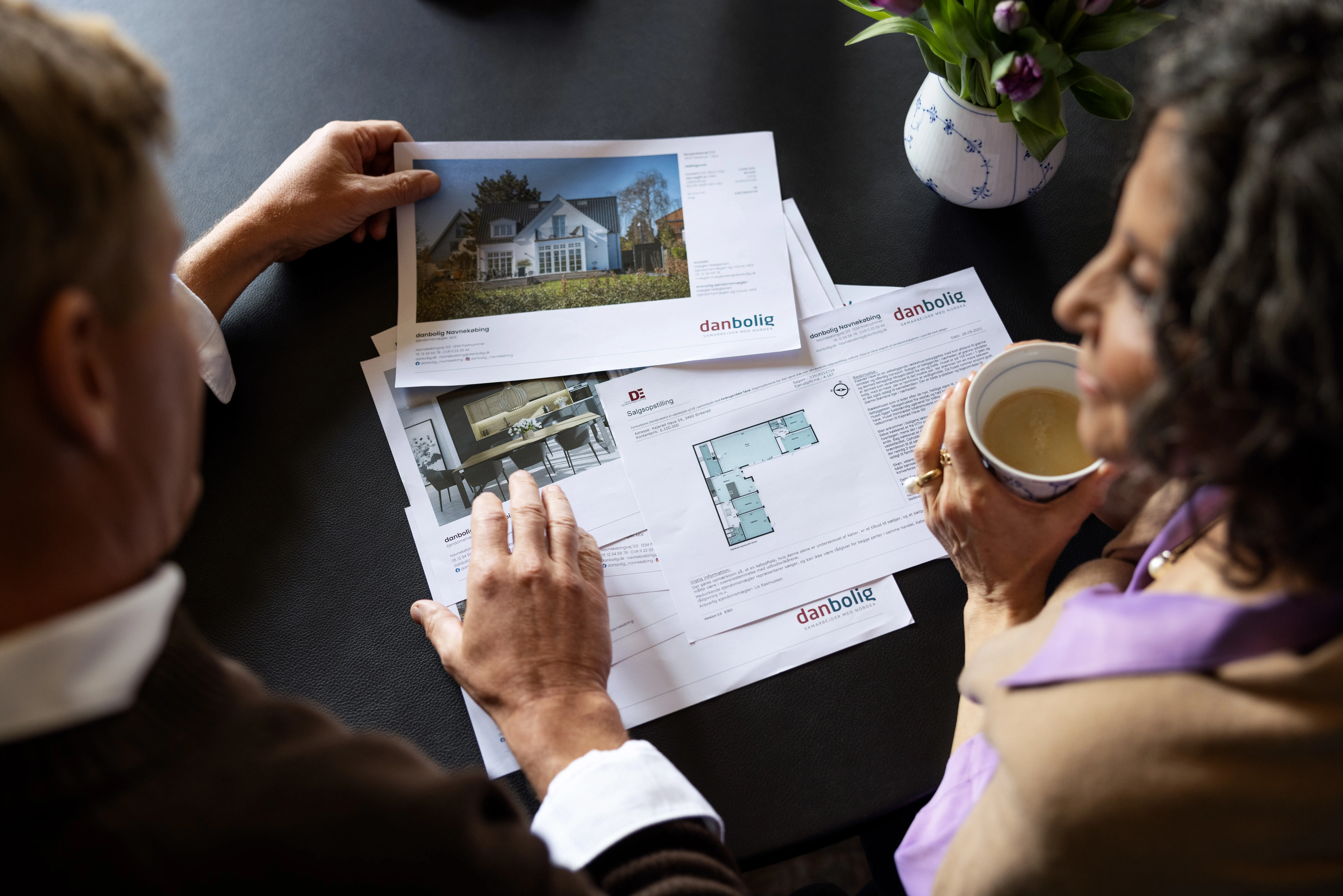 To personer kigger på salgsopstilling ved bord