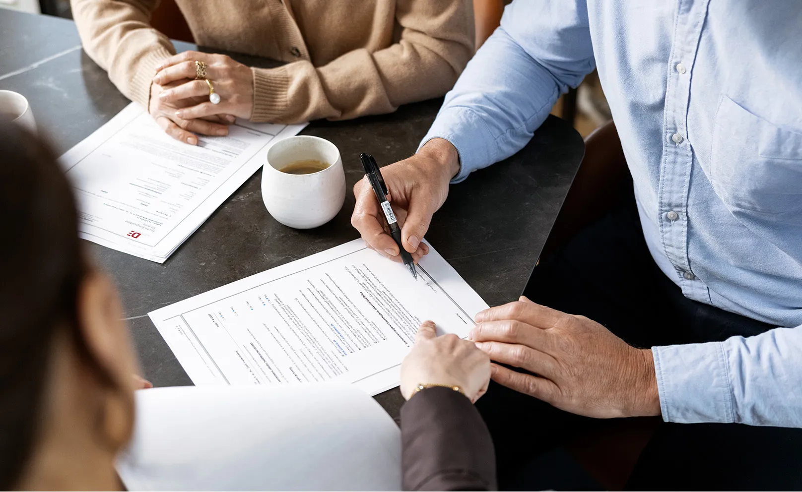 Mand underskriver dokument fra ejendomsmægler