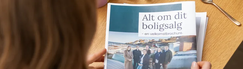 Kvinde læser velkomstbrochure fra danbolig