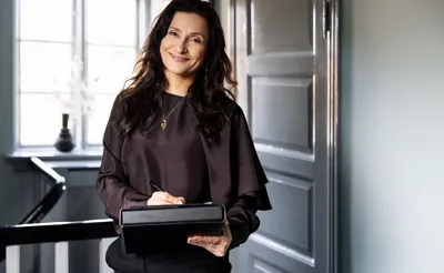 Ejendomsmægler smiler og skriver på en blok