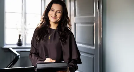 Ejendomsmægler smiler og skriver på en blok