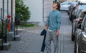 Ung mand står på gaden og kigger op på lejlighedsbyggeri